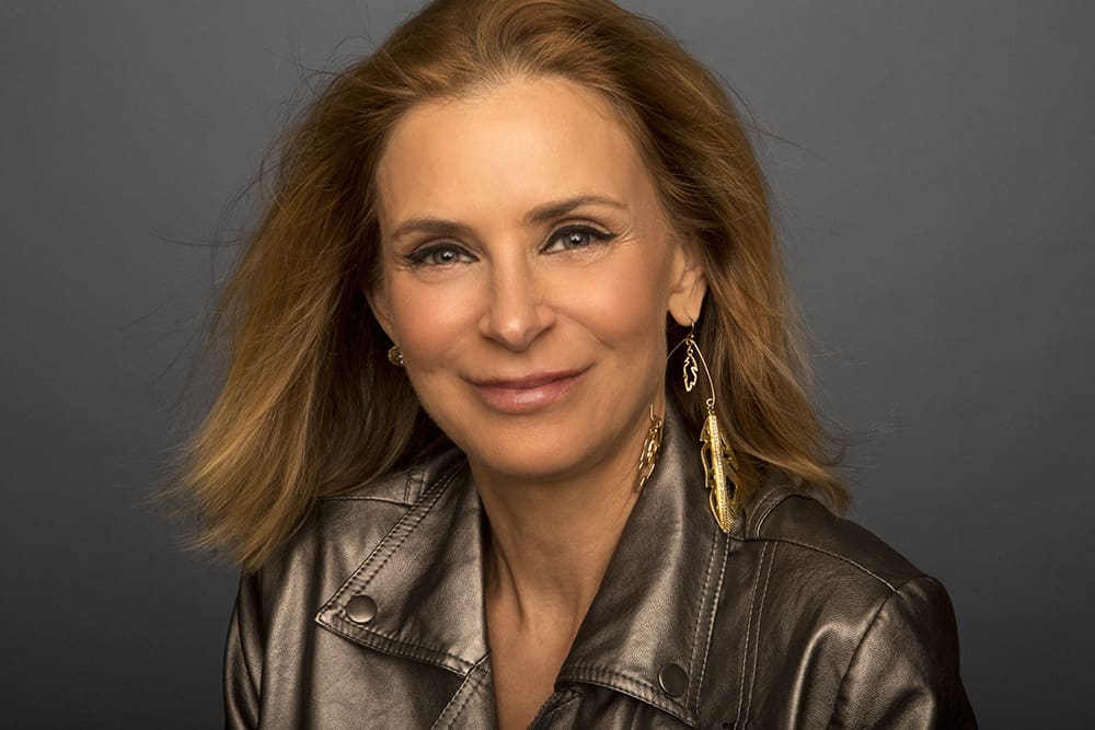 A woman with long hair wearing a leather jacket.