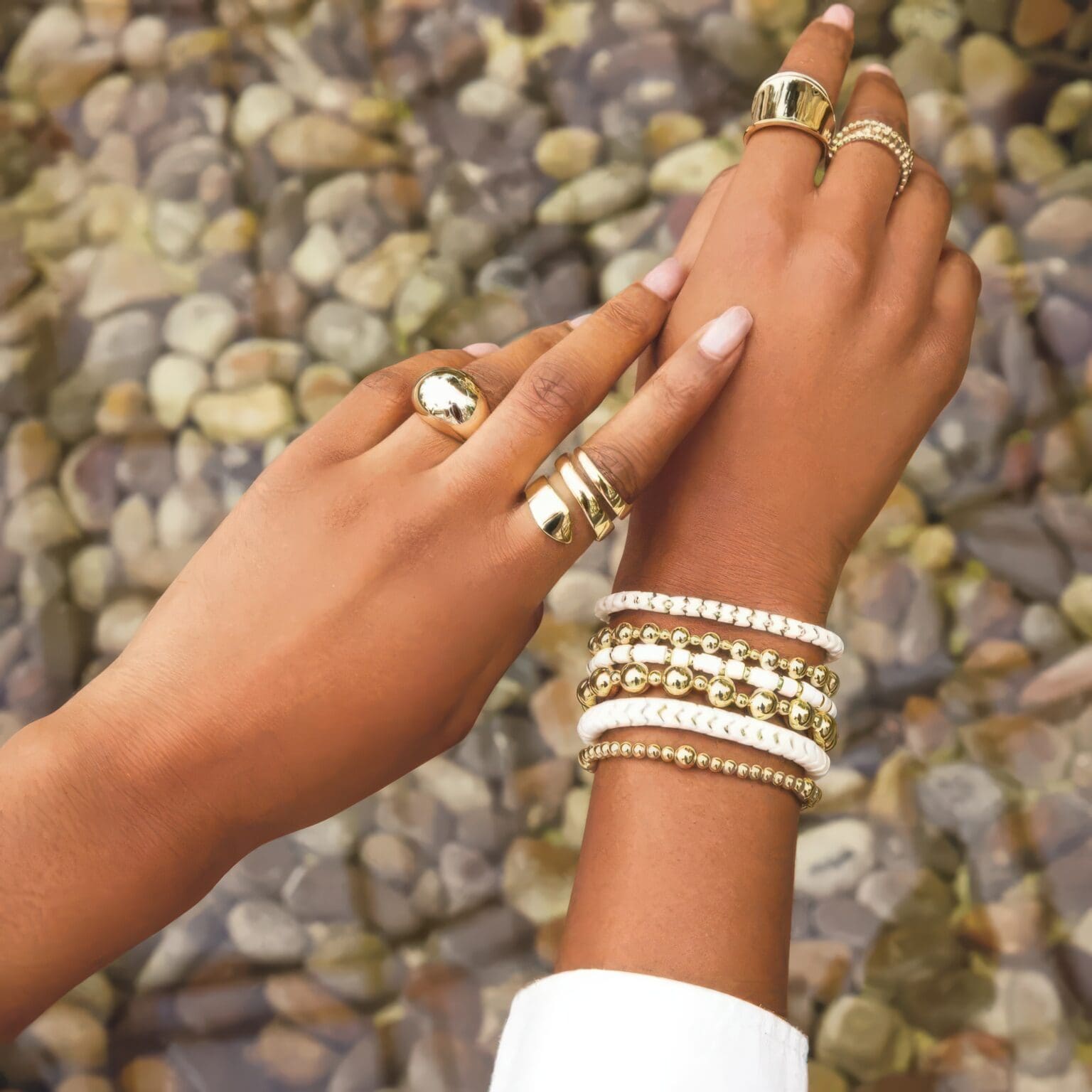 A woman 's hands with rings and bracelets on her fingers.