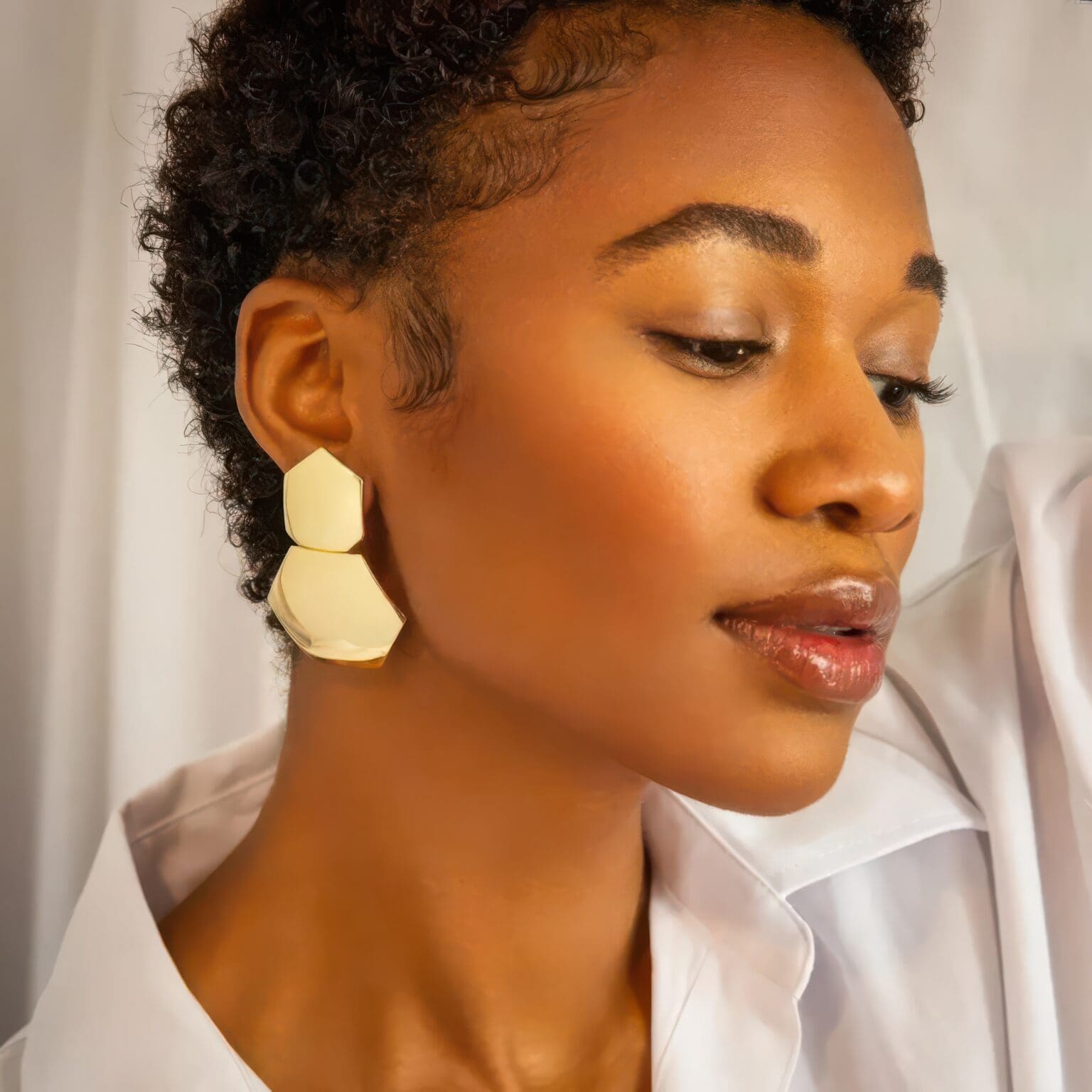 A woman with short hair wearing earrings.