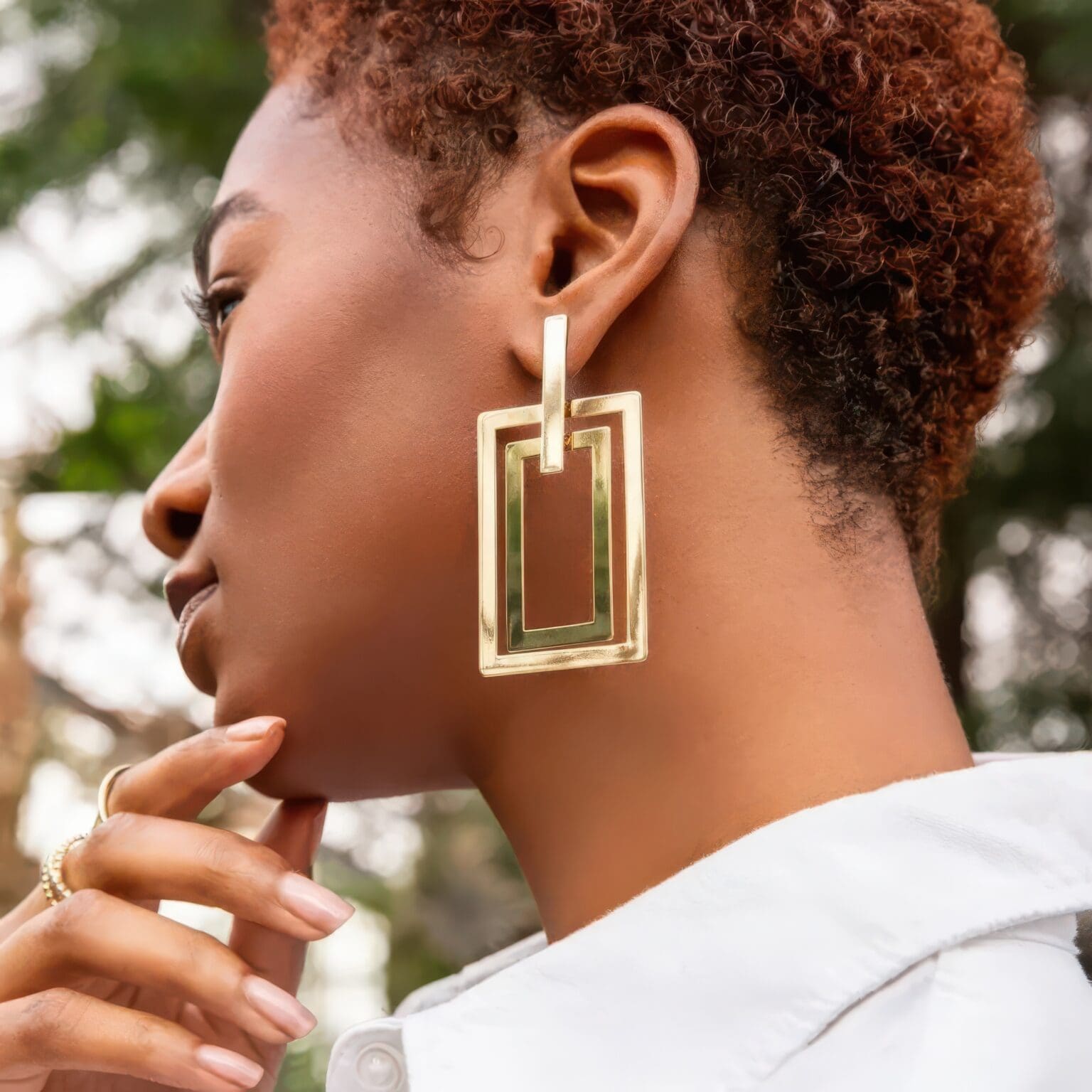A woman with short hair wearing earrings.