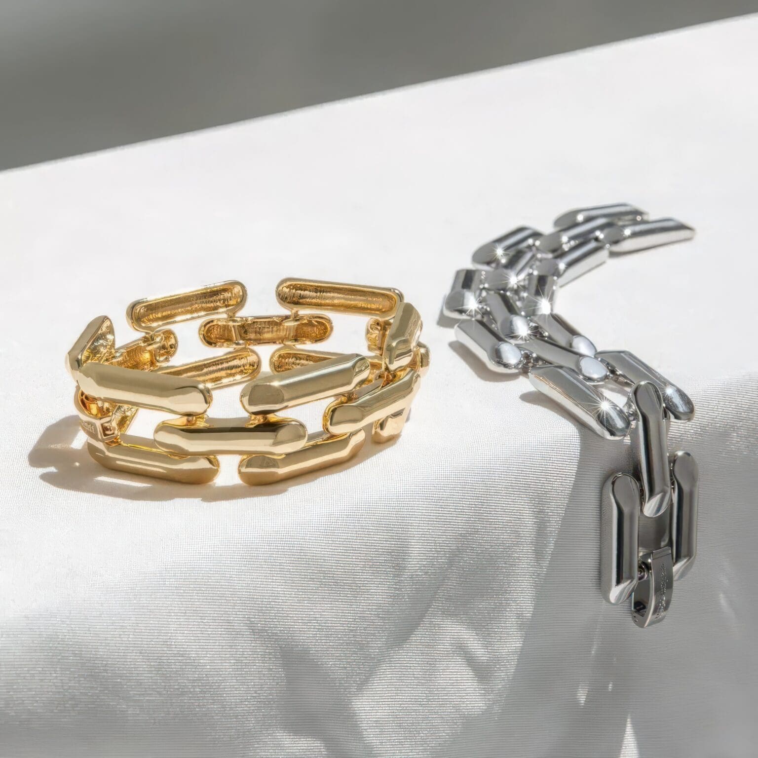 A gold and silver chain link ring on top of a white cloth.