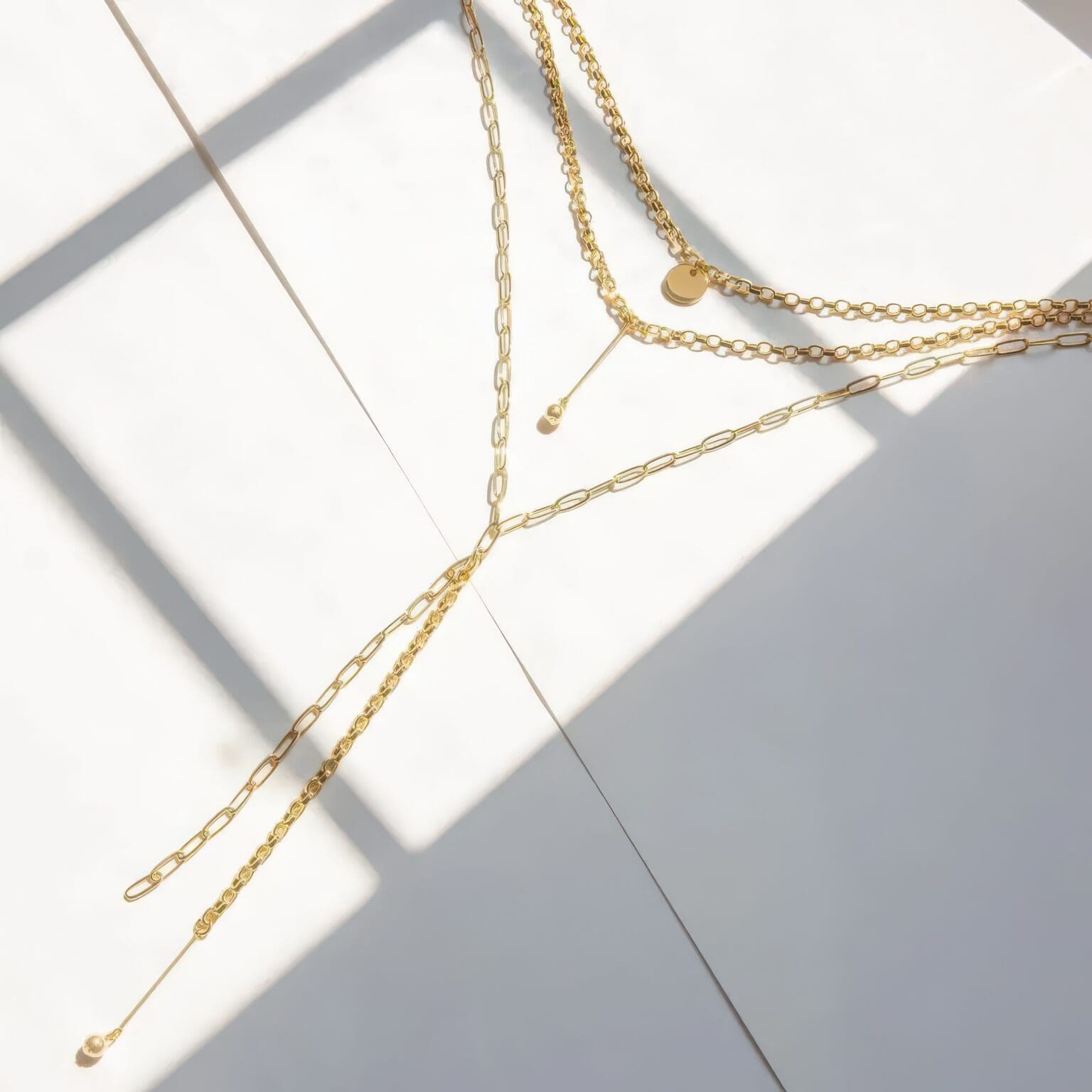 A white table with some gold chains and a light