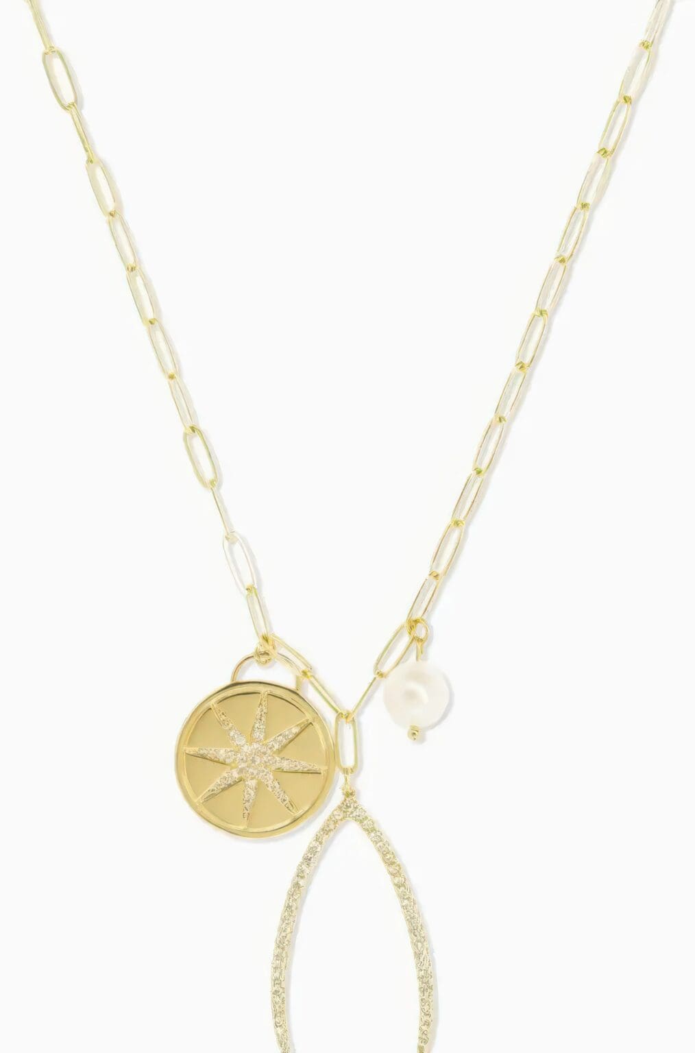 A gold necklace with two charms on it.