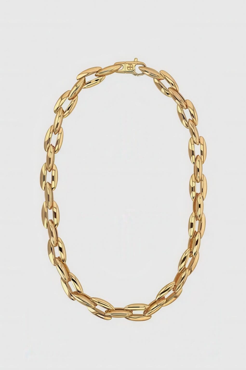 A gold chain necklace with a large link.