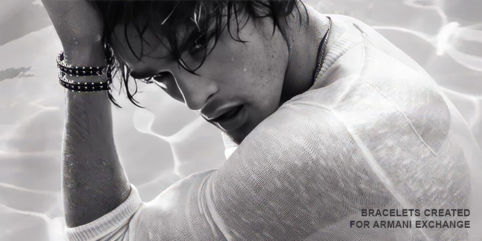 A man with wet hair and white shirt leaning on his arm.