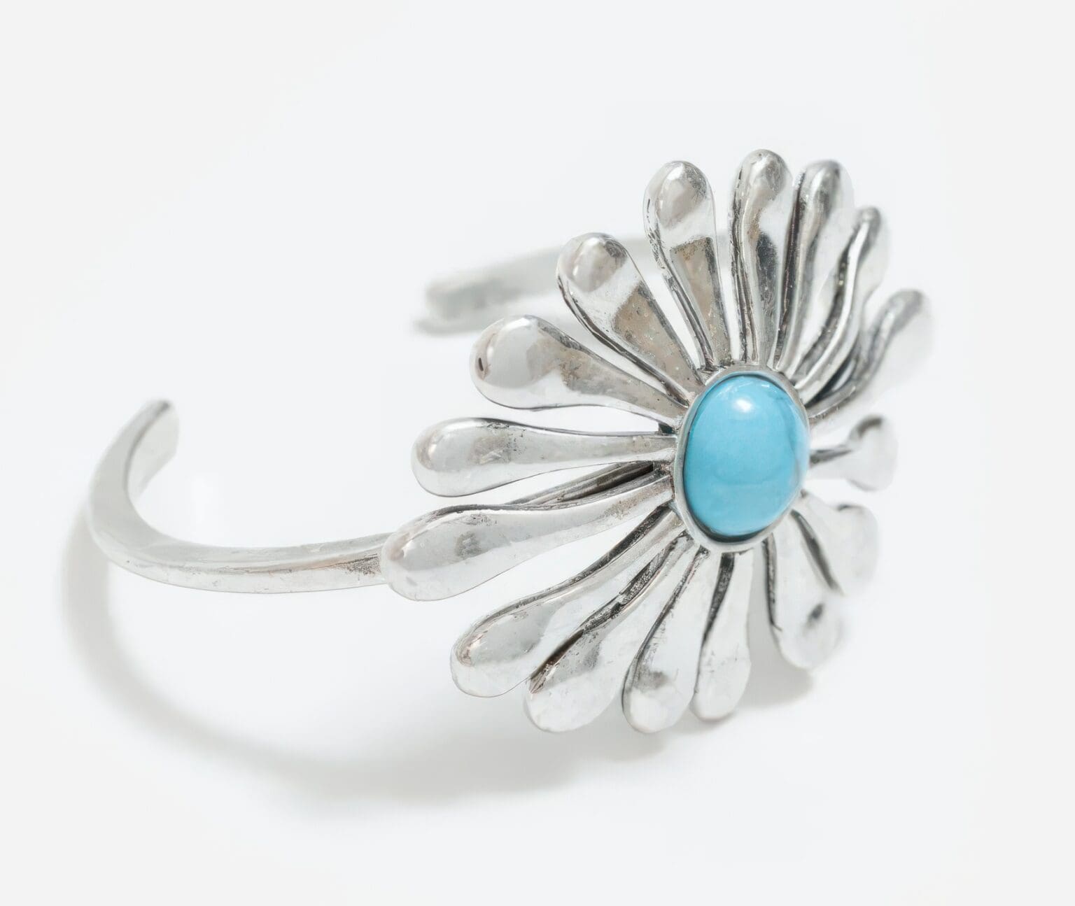 A silver bracelet with a blue stone on it.