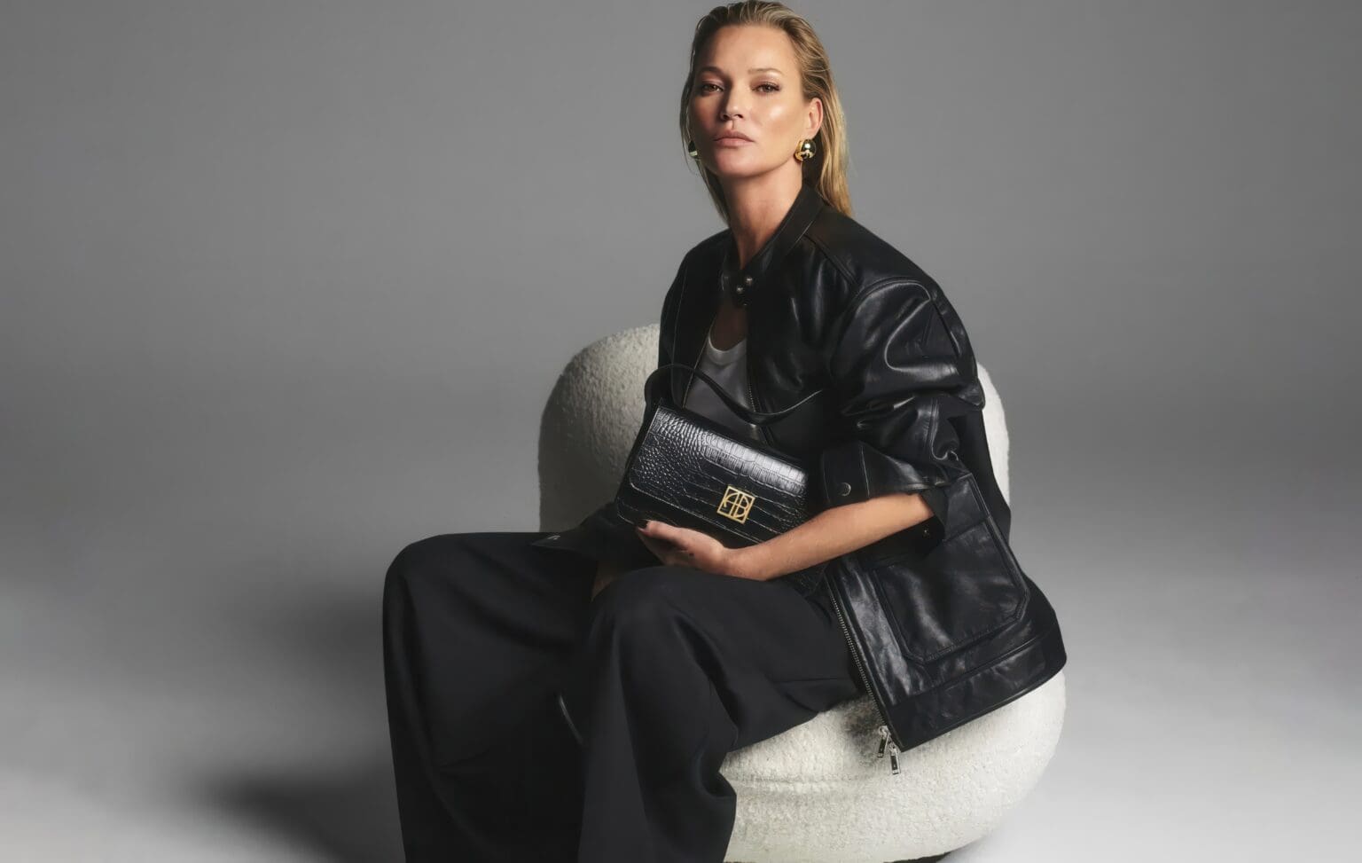 A woman sitting on a chair holding a purse.