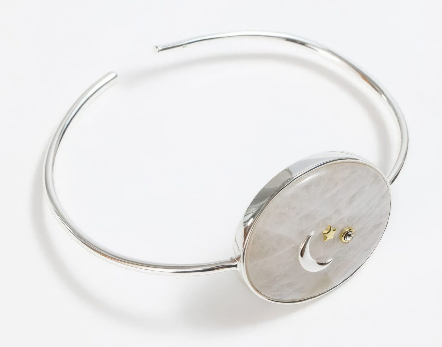 A silver bracelet with a button on it.