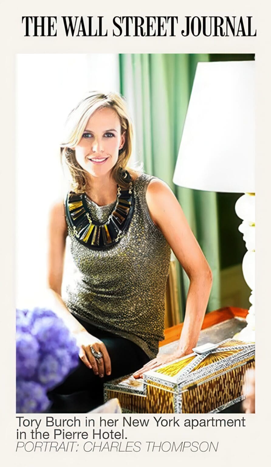 A woman in a black and gold top sitting on the floor
